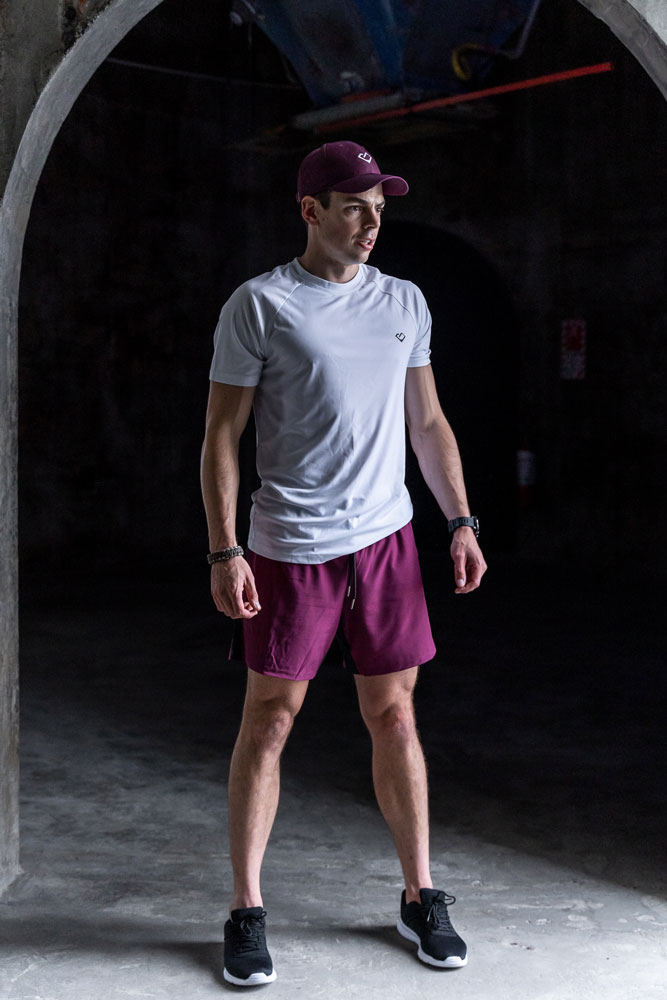 Jared, founder and head coach, in training kit under a concrete arch